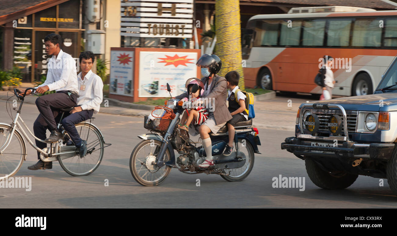Cambodian family riding on a motor bike in the rush hour, mum and two children Stock Photo