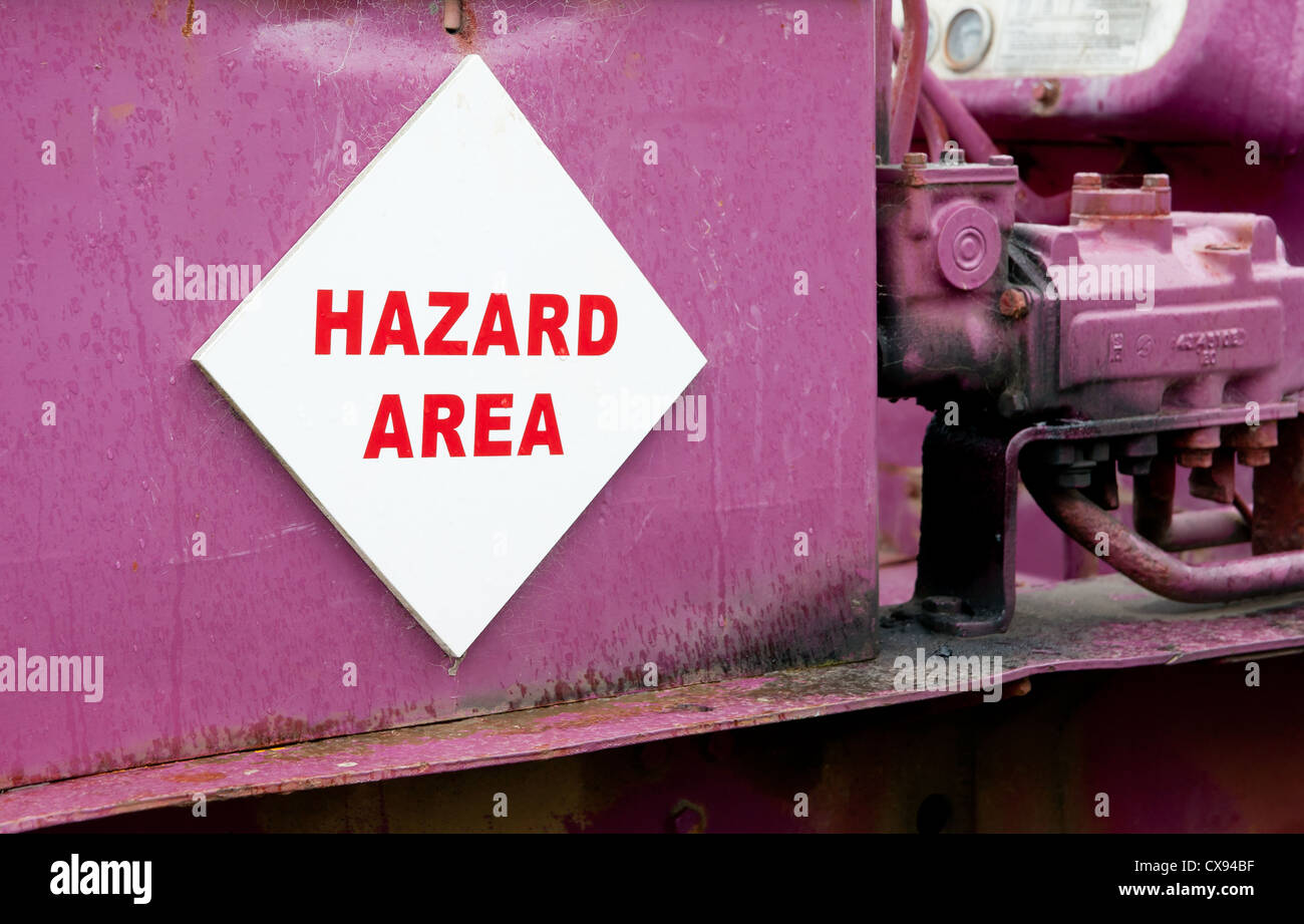 Hazard sign on abandoned pink bulldozer. Stock Photo