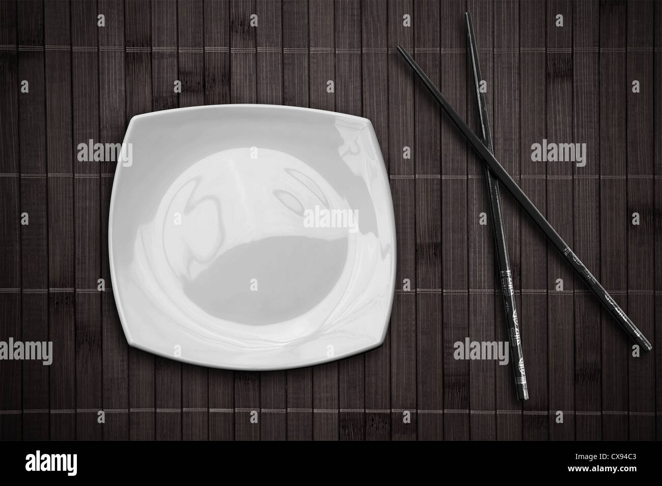 square plate over bamboo placemat setting with sticks Stock Photo Alamy