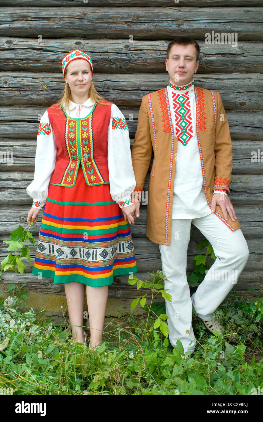 Young man and woman in national dress of the Belarus near the wall of old house. Stock Photo
