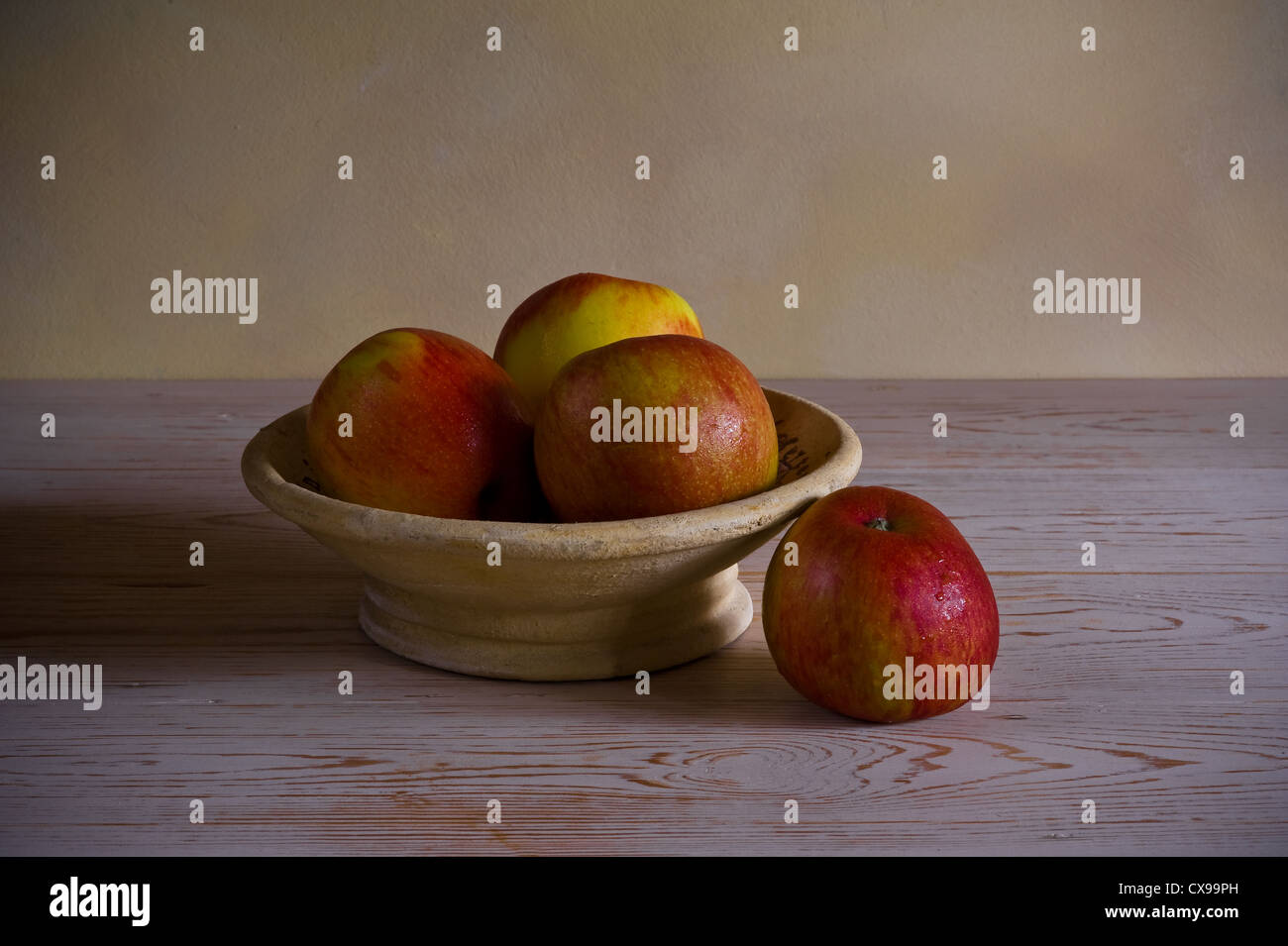 Bowl of apples lit by a soft window light. Stock Photo