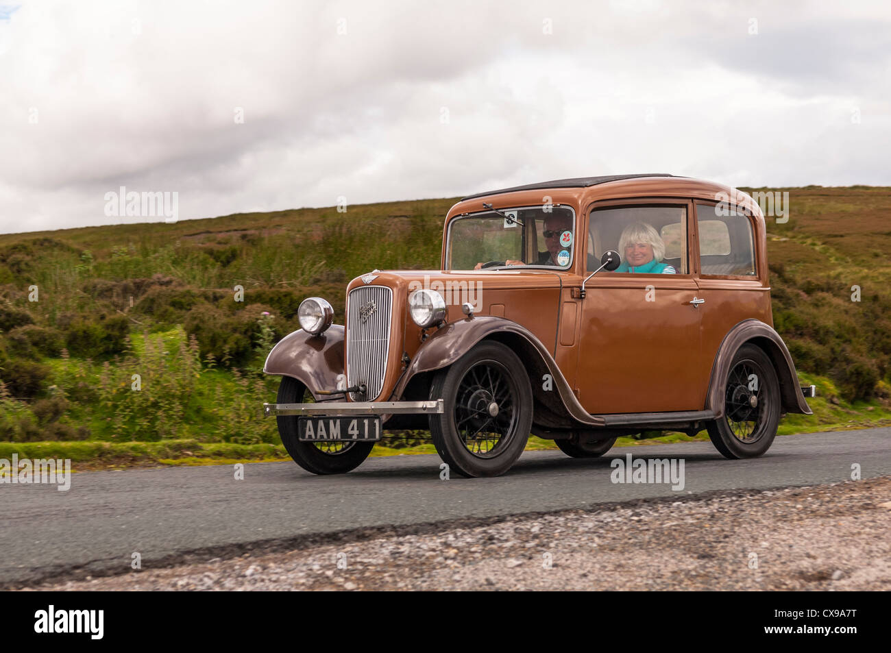 A vintage Austin 7 classic car driving through the Yorkshire Dales showing movement in Yorkshire , England , Britain , Uk Stock Photo