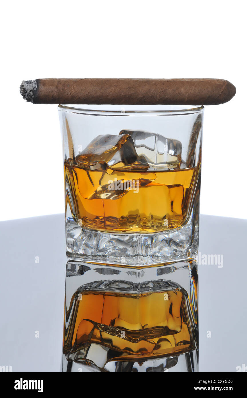 Lit Cigar on Whiskey Glass with Ice Cubes and reflections in Table Top - white background Stock Photo