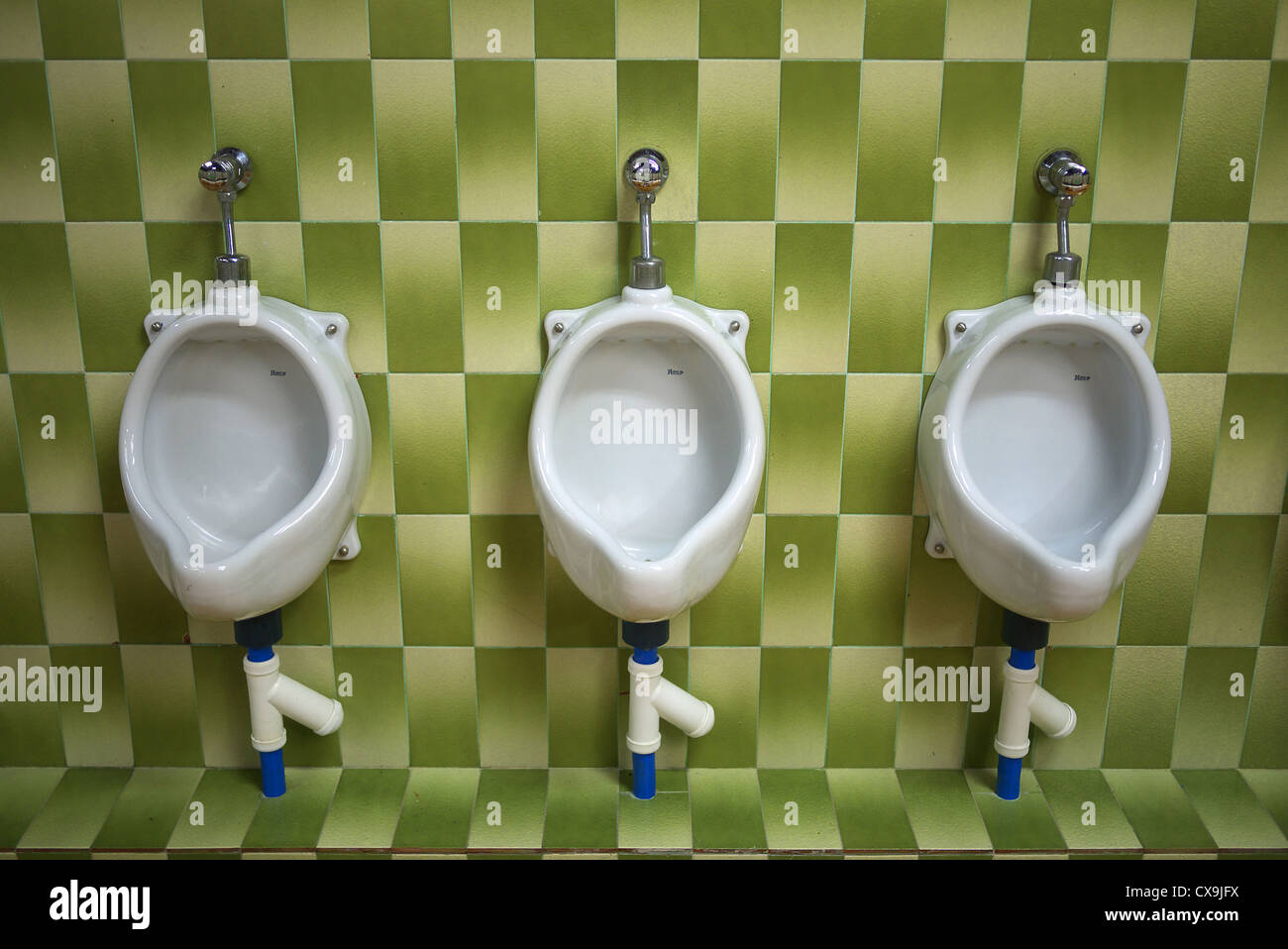 Green tiles inside a men's toilet in Spain. Stock Photo