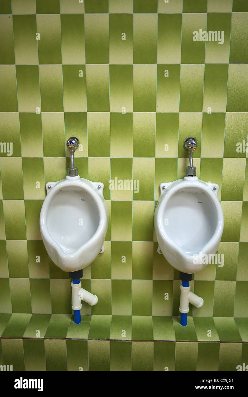 Green tiles inside a men's toilet in Spain. Stock Photo