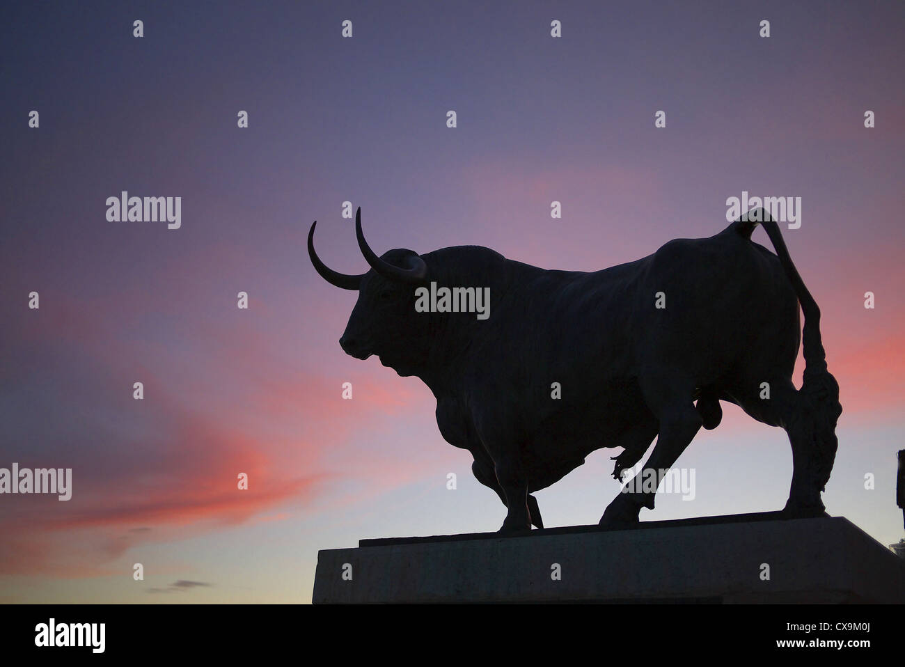 Sculpture of a bull silhouetted against the evening sky in Tordesillas, Spain. Stock Photo
