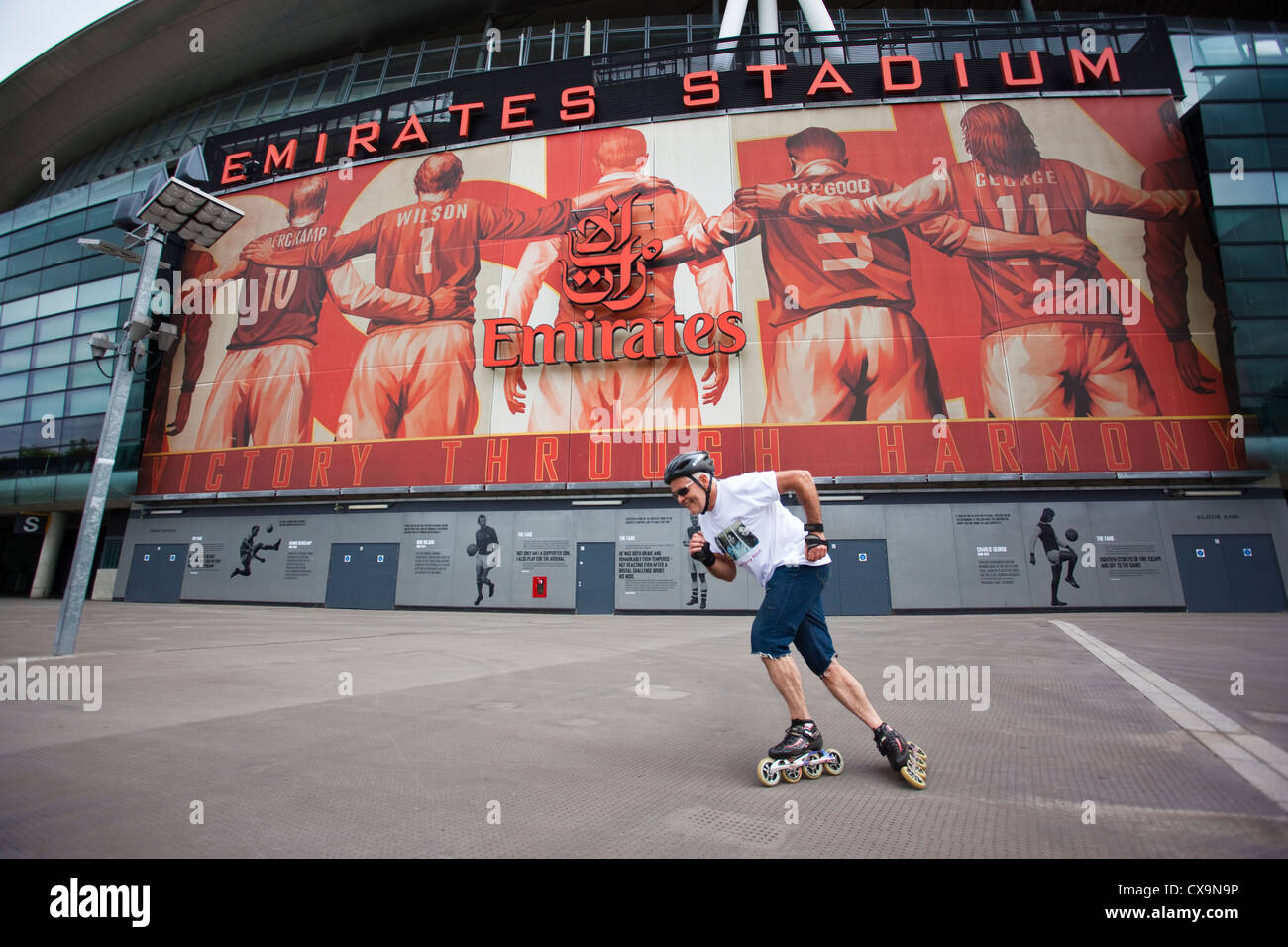 Man roller blading outside the Emirates Stadium, home of the Arsenal Football Club, Finsbury Park, North London, England, UK Stock Photo