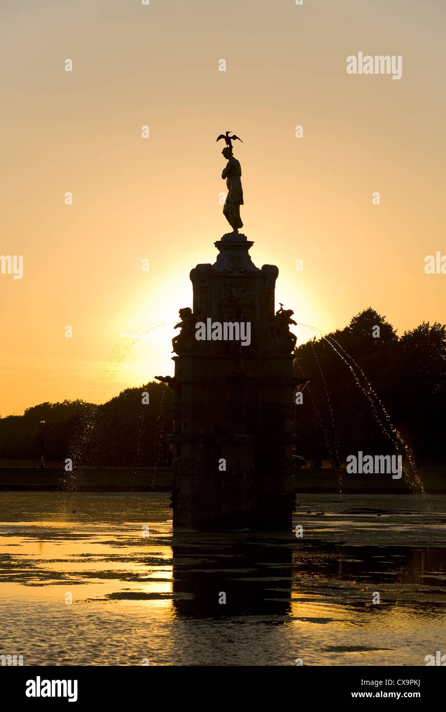 The Arethusa 'Diana' Fountain Bushy Park UK  at sunset, shown after re-gilding, restoration & cleaning. A bird is on the statue. Stock Photo