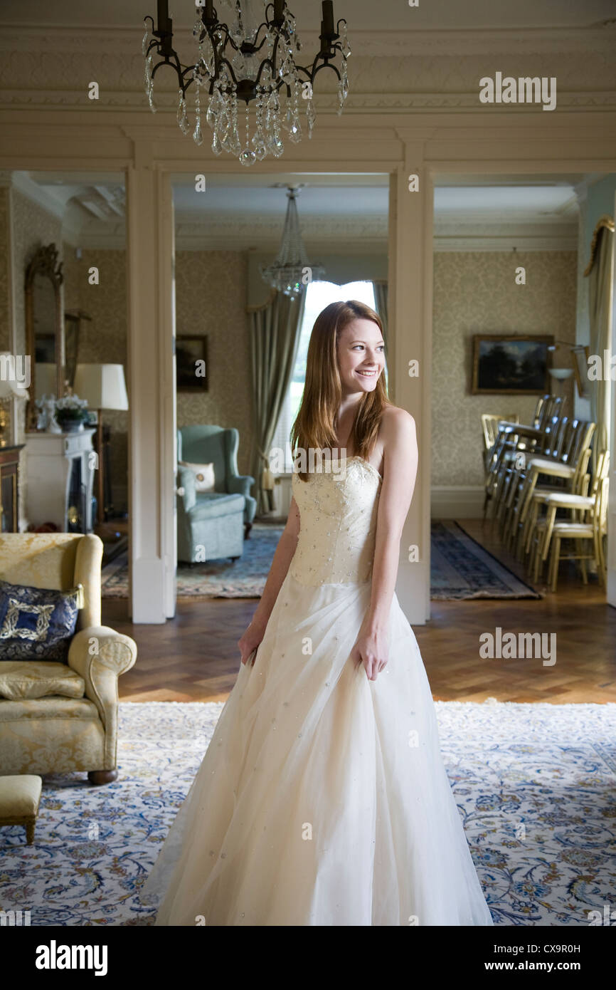 Young brunette woman in cream chiffon wedding dress in stately home  interior Stock Photo - Alamy