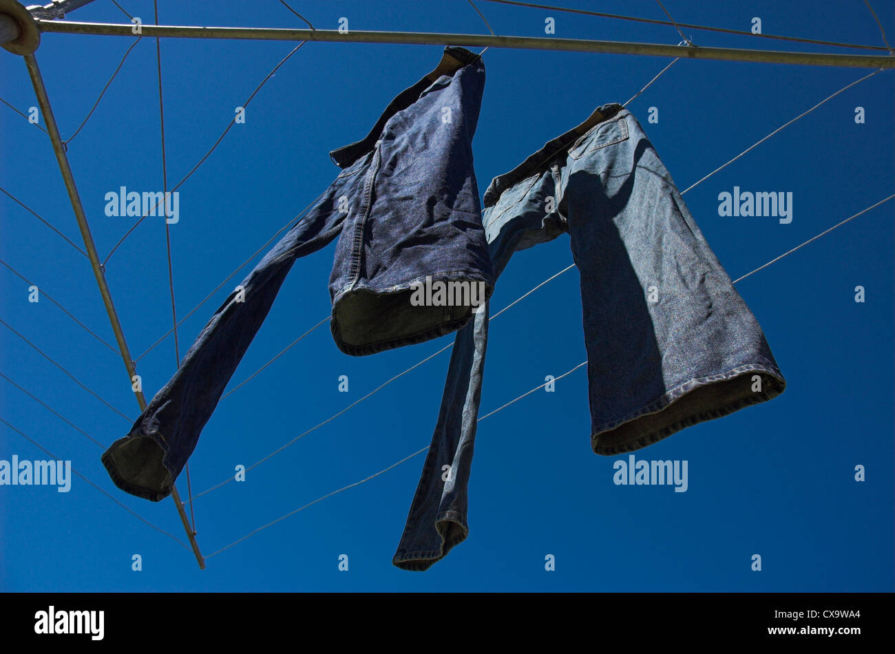 Denim jeans hanging on a Hills Hoist in an Australian backyard. Stock Photo