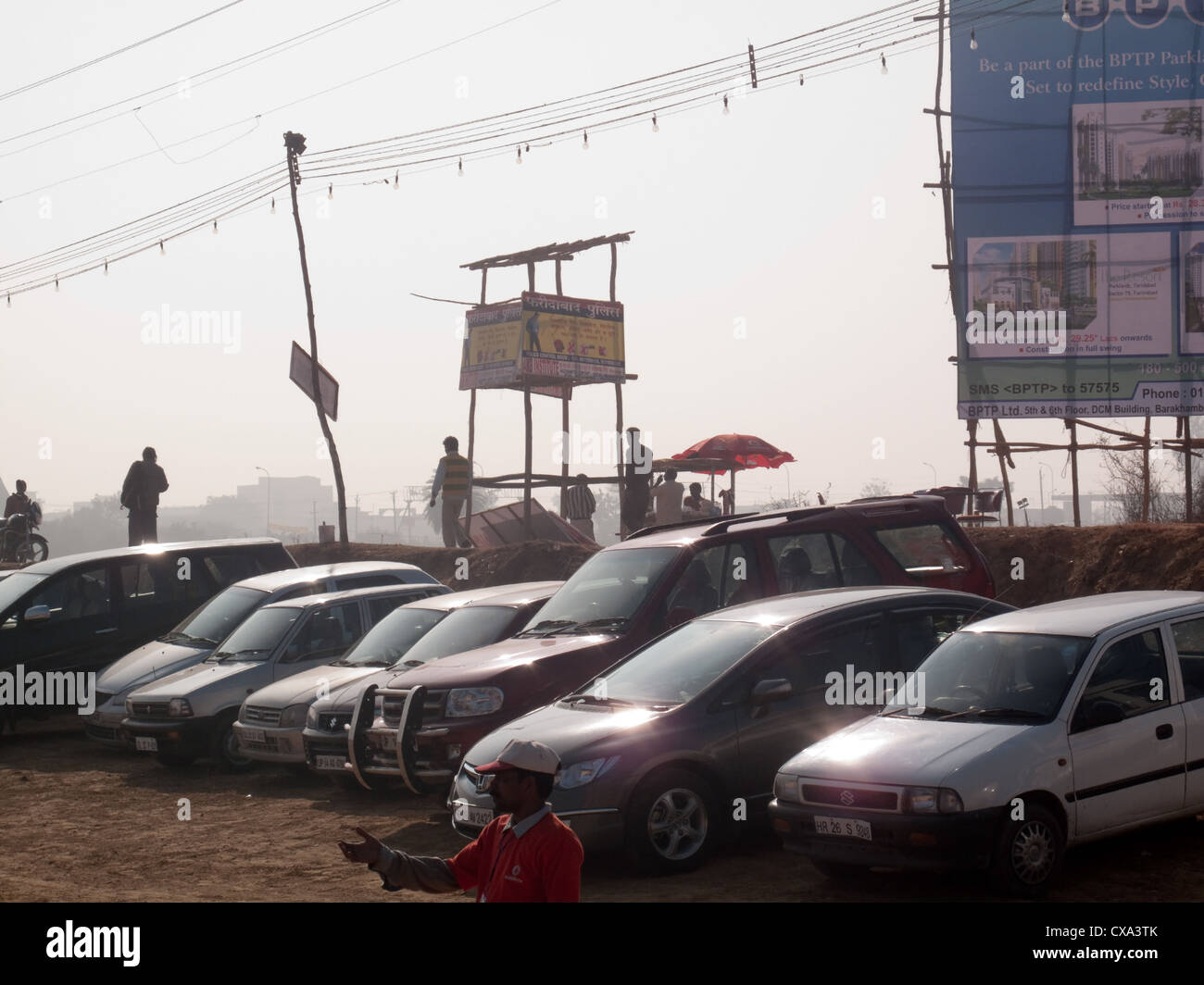 Cars in a parking lot at Surajkund, a cultural fair that is being held in the state of Haryana in India, with a security post. Stock Photo