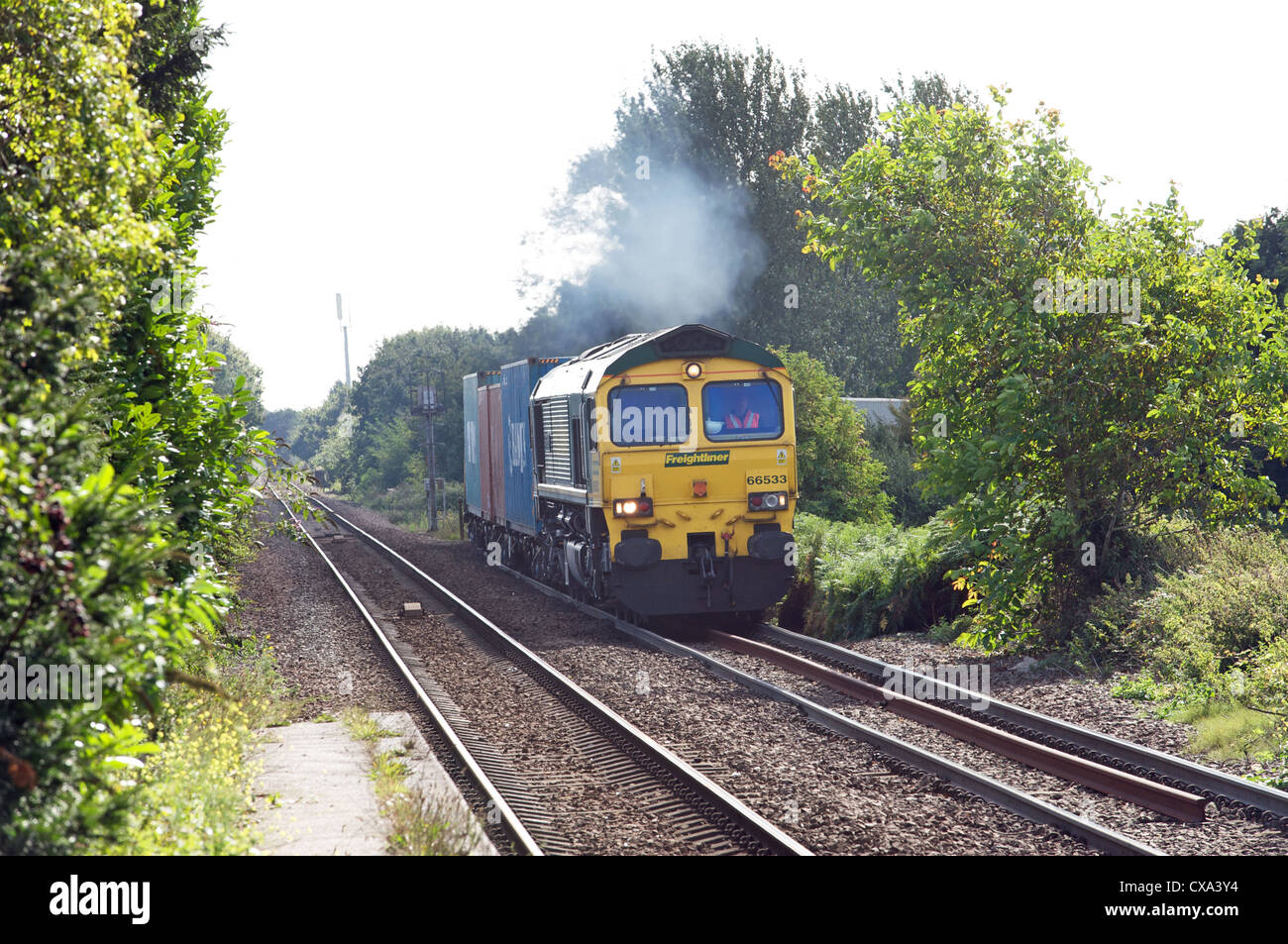 Freight train from the port of Felixstowe about to join the single track branch line to Ipswich at Trimley, Suffolk, UK. Stock Photo