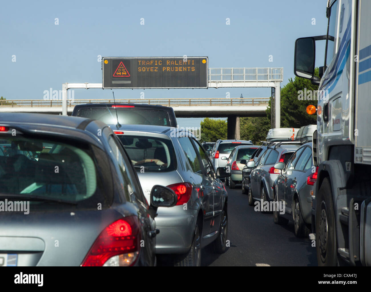 Traffic jam on the French Autoroute in August with warning sign on