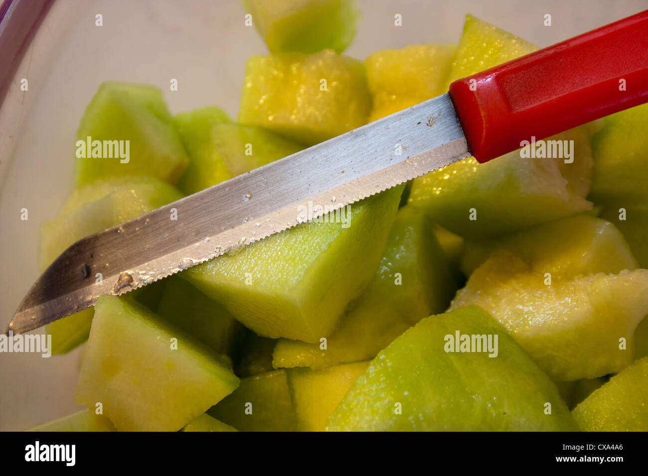 Macro (close up) photo of knife over bowl of cut musk melon. We were cutting some fruit at home, and I tried to get a macro shot Stock Photo