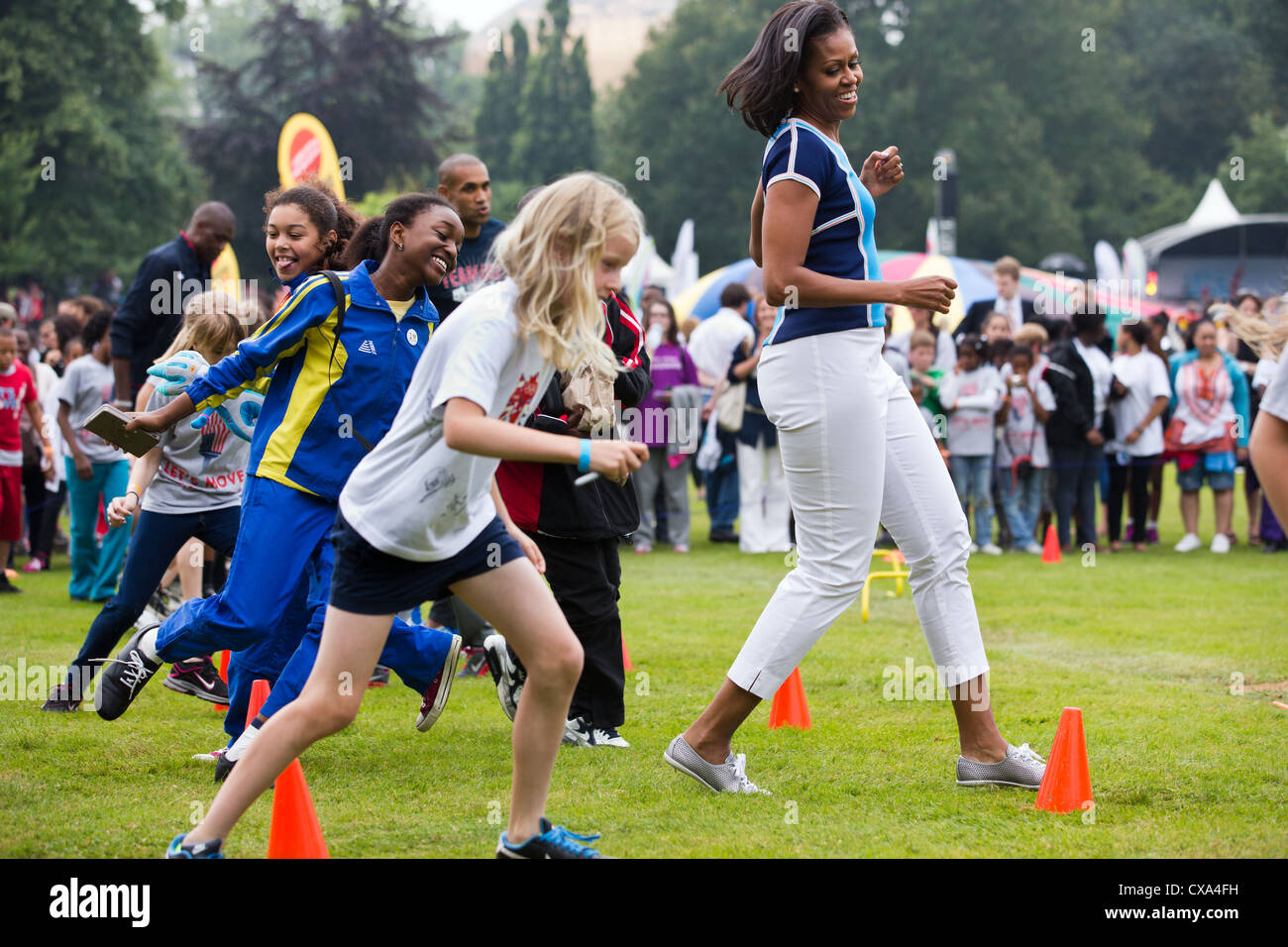Michelle Obama runs at an activity station during a “Let’s Move! London” event at Winfield House in London, England Stock Photo