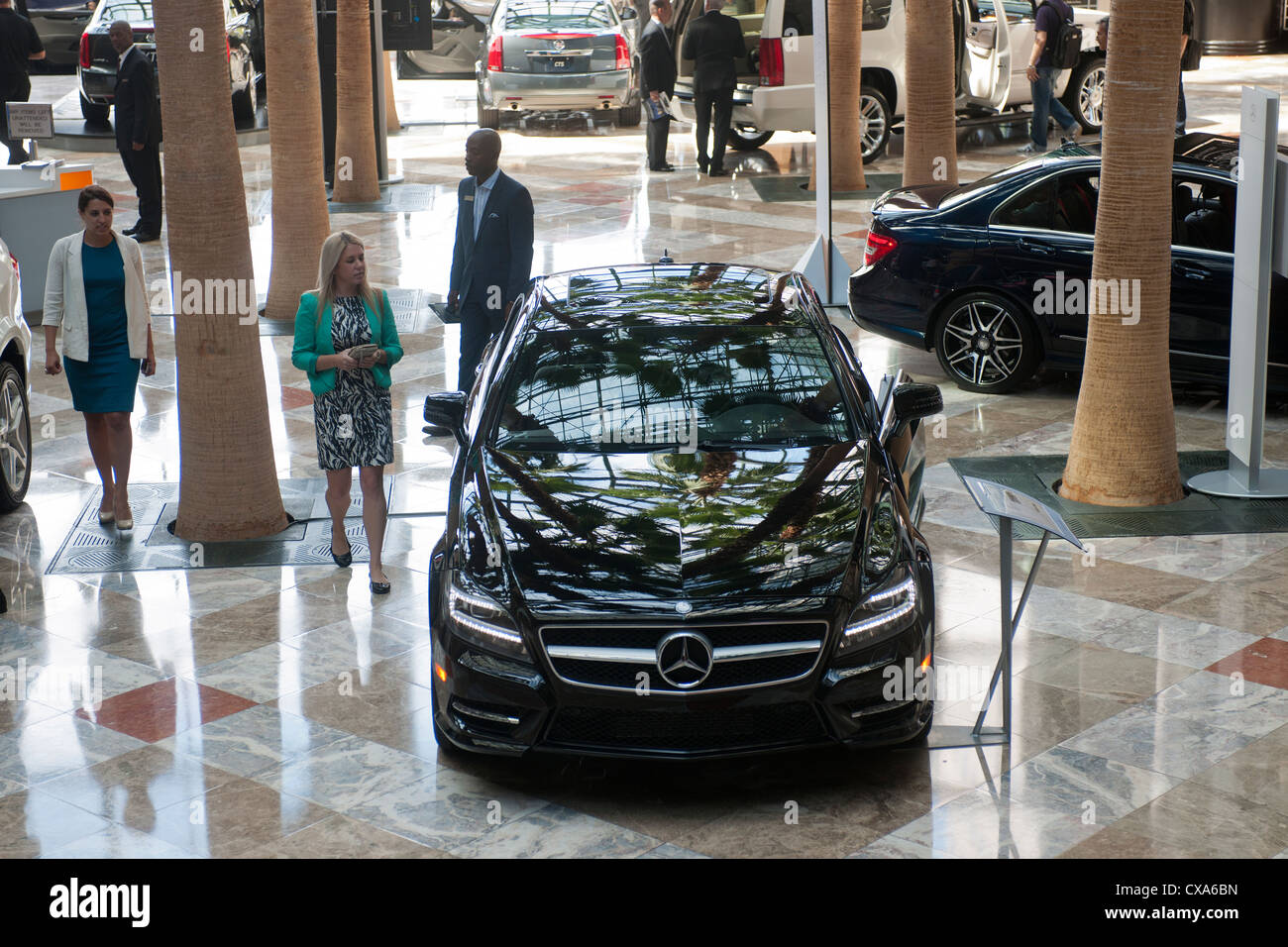 Customers examine Mercedes-Benz luxury vehicles on display Stock Photo