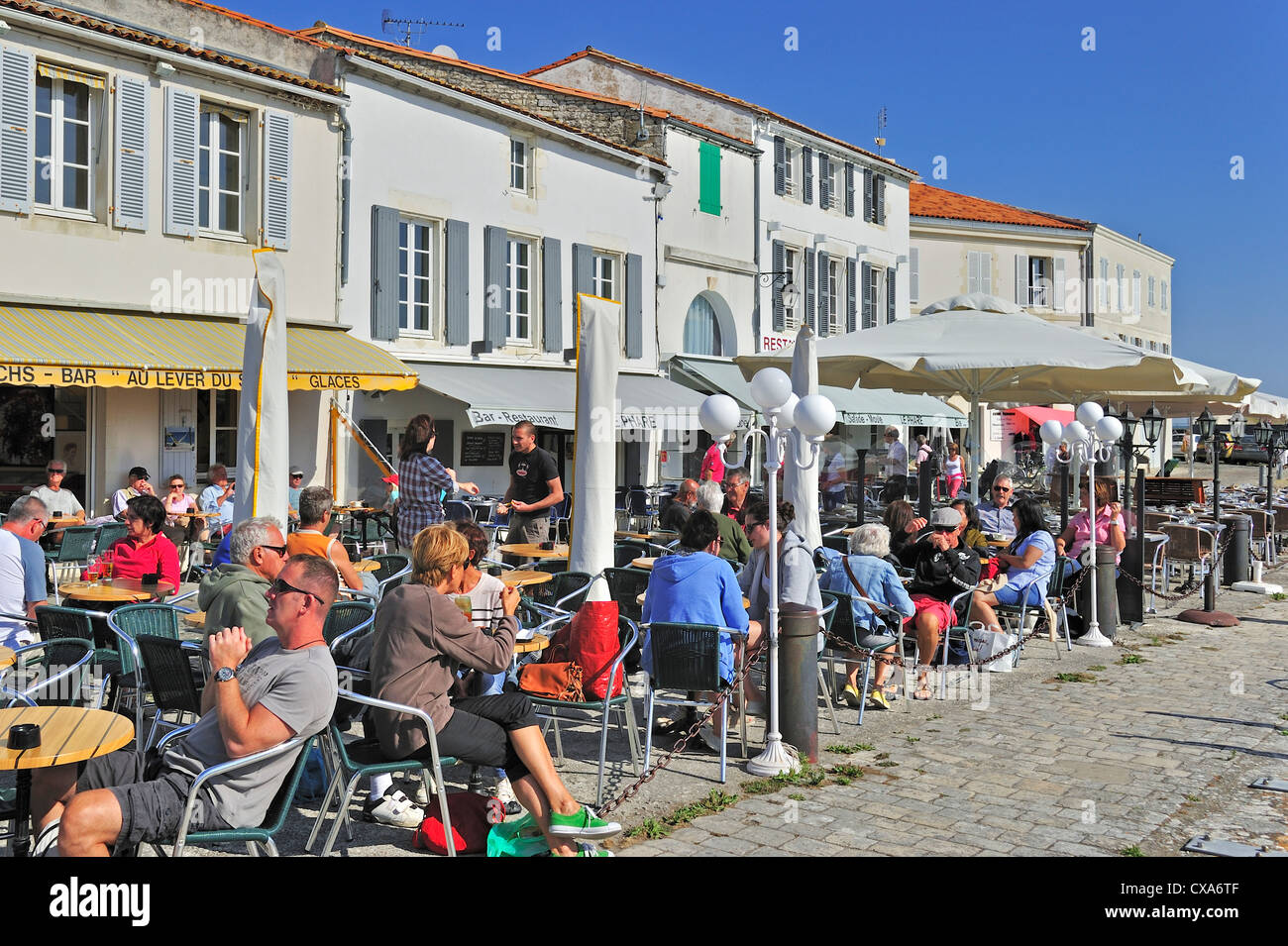 Tourists at pavement cafe in the port at Saint-Martin-de-Ré on the island Ile de Ré, Charente-Maritime, France Stock Photo