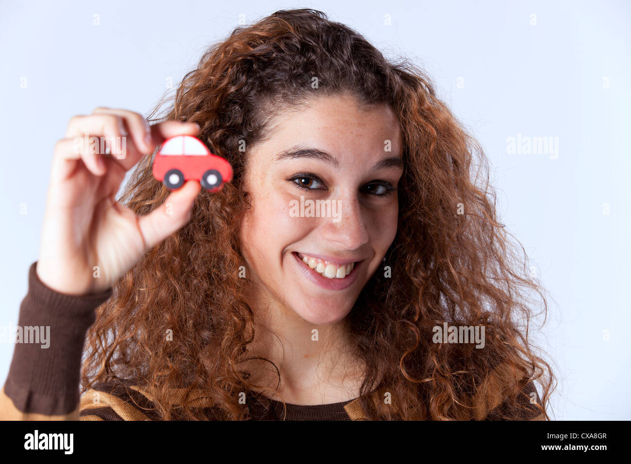 Happy young woman showing a small red car Stock Photo - Alamy
