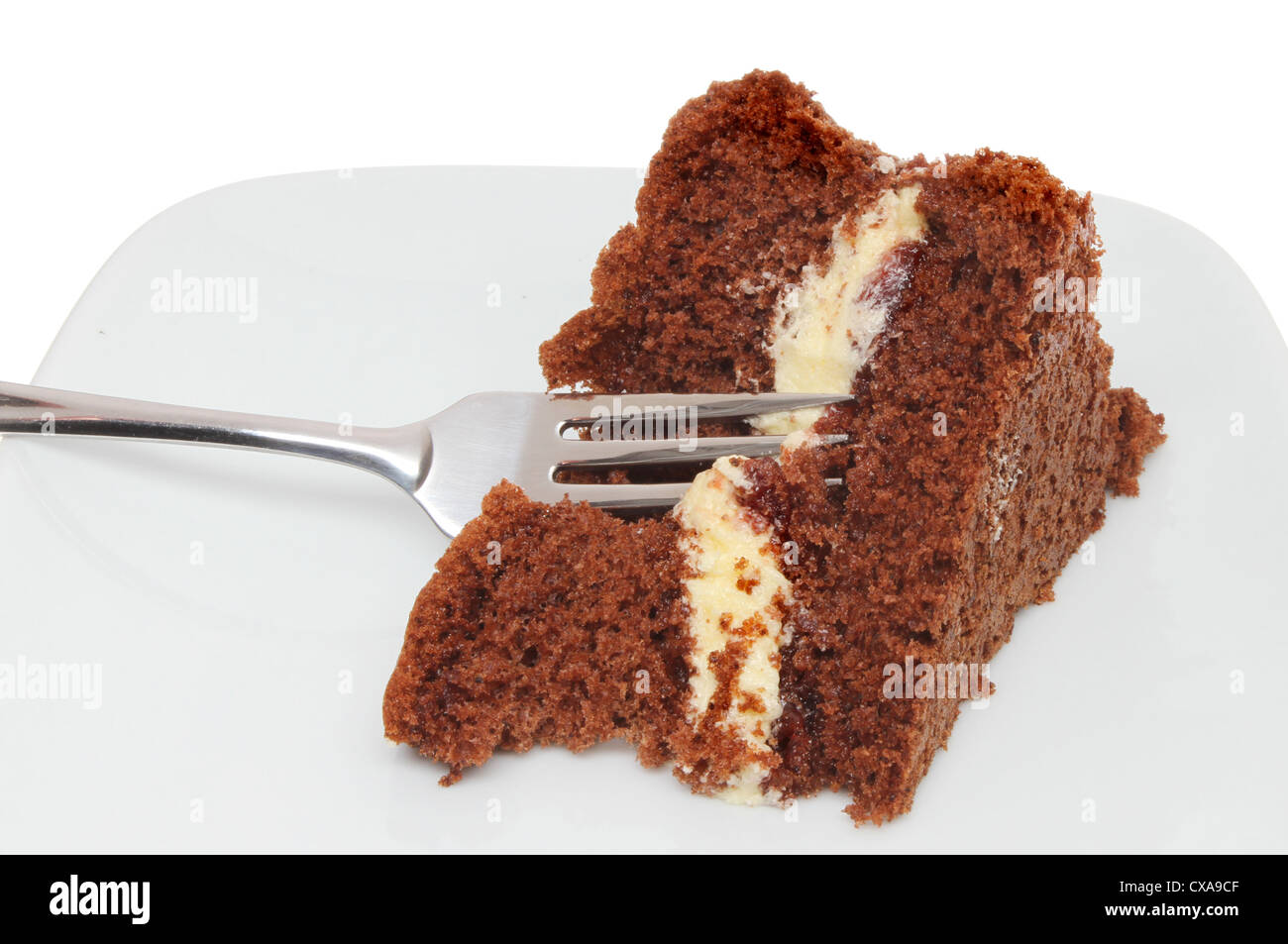 Slice of chocolate sponge cake with a fork on a plate Stock Photo