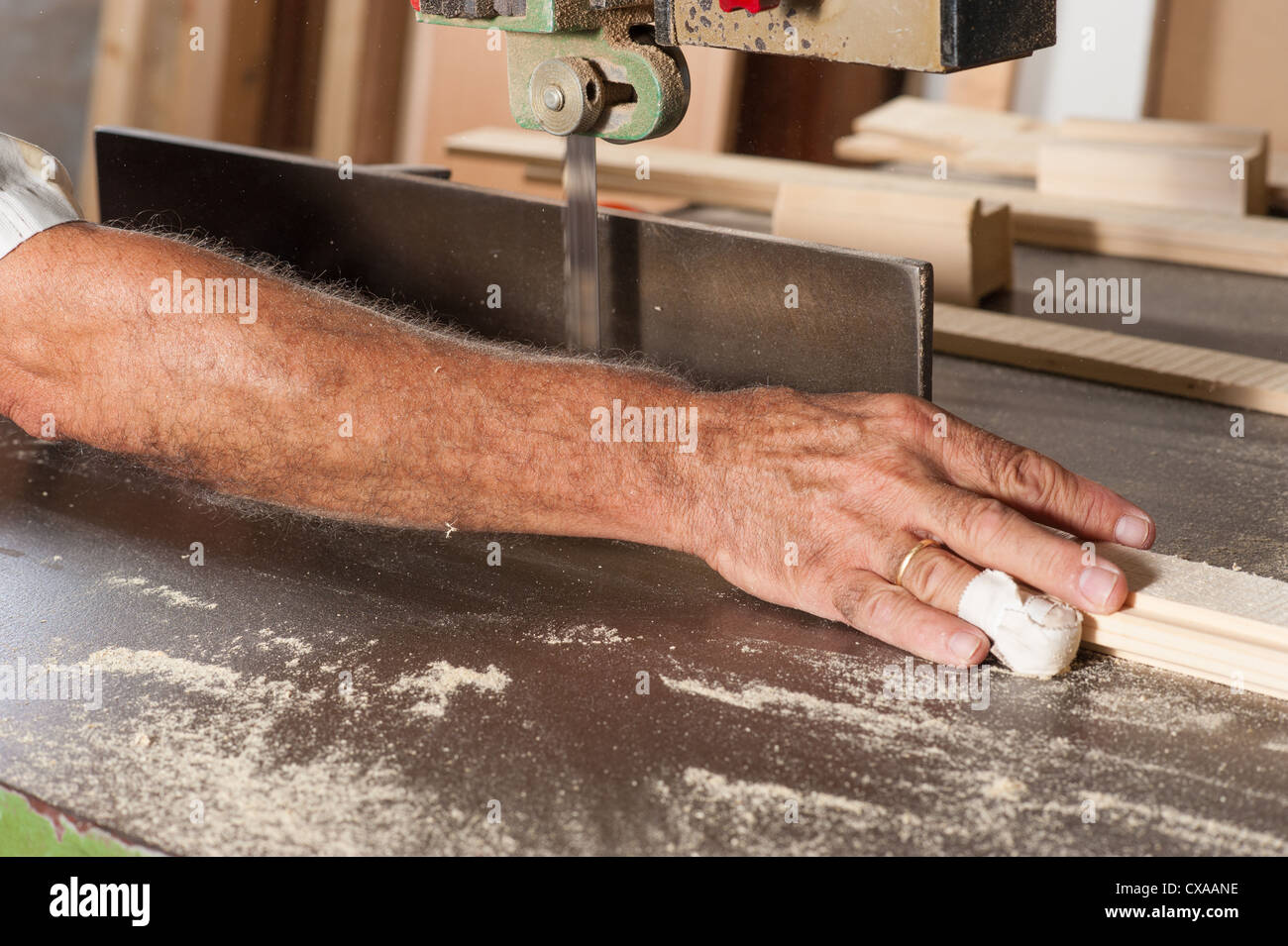 Carpenter working at a saw with a bandaged finger Stock Photo Alamy