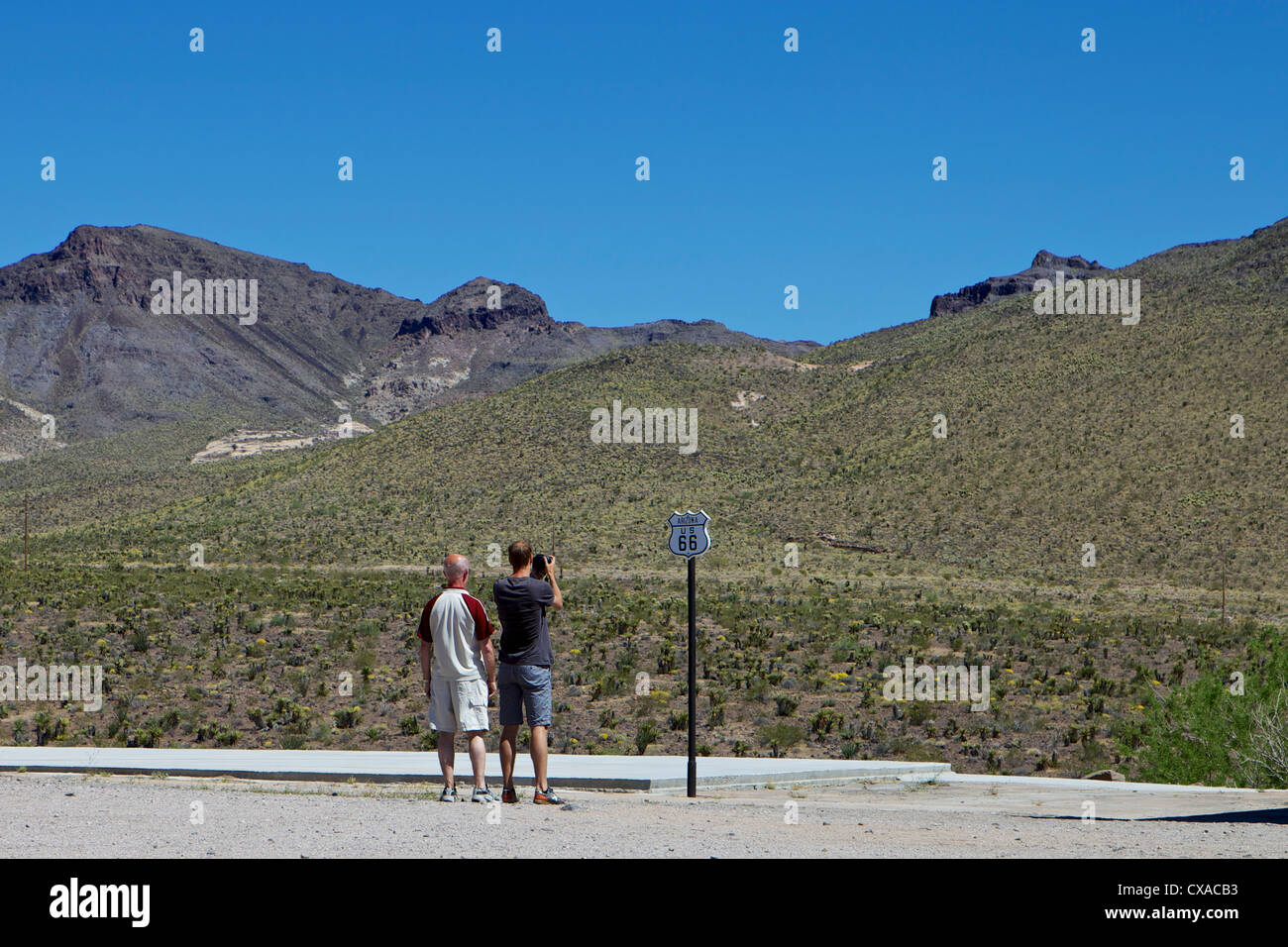 Tourists taking a picture of a Route 66 sign in the Arizona desert at Cool Springs Station near Kingman, Arizona Stock Photo
