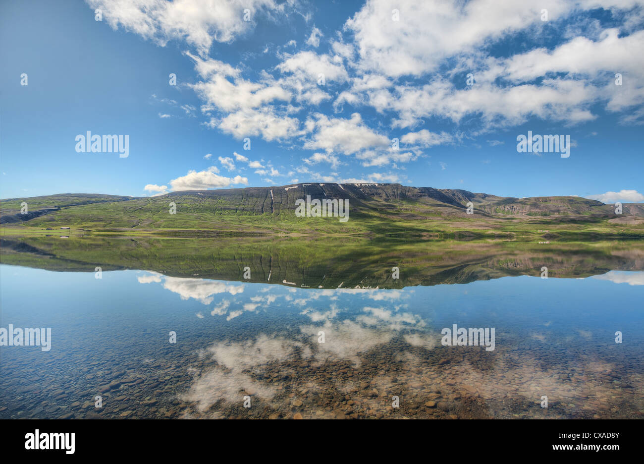 A mountain is reflected in the stillness of lake water at Ljósavatn near Akureyri in northern Iceland Stock Photo
