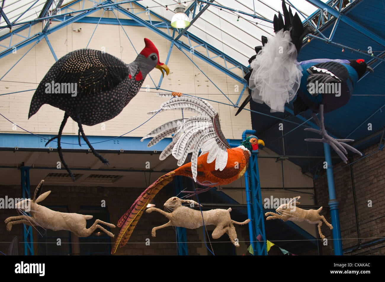 Art installation of game birds and leaping hares hanging from the roof of the market hall during Abergavenny Food Festival Stock Photo