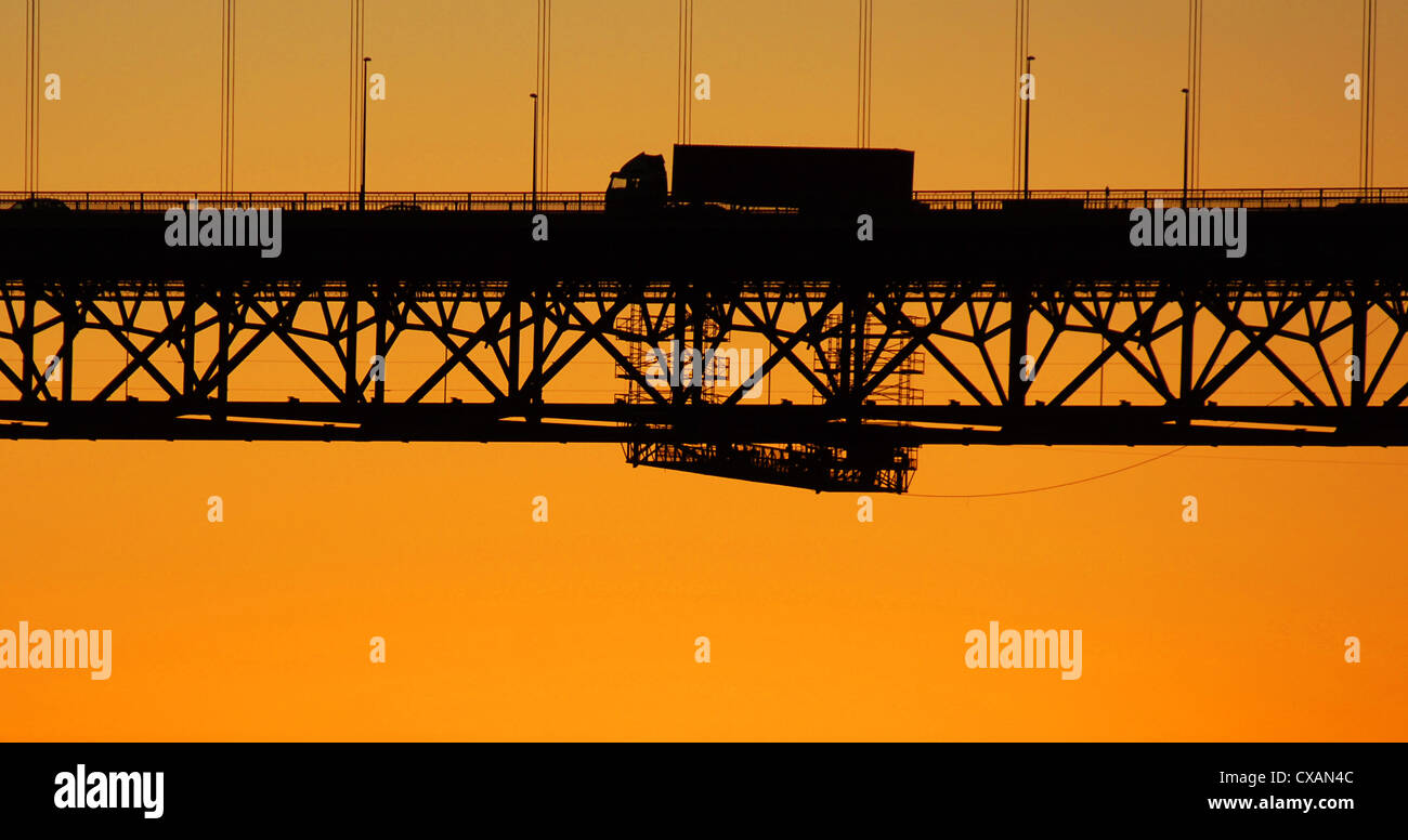 silhouette of a truck crossing the forth road bridge at sunset. Stock Photo