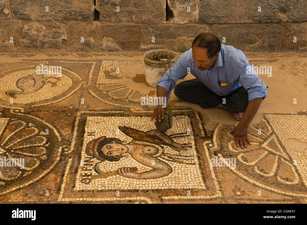 caretaker cleaning Byzantine mosaic in the church in Petra, the UNESCO World Heritage Site in Jordan Stock Photo