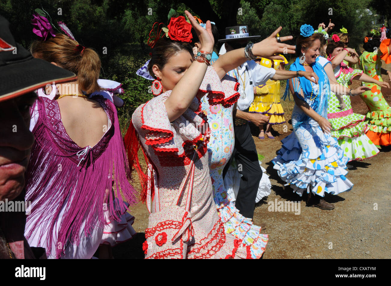 Women dancing in national flamenco dress on track during annual Romaria. Stock Photo