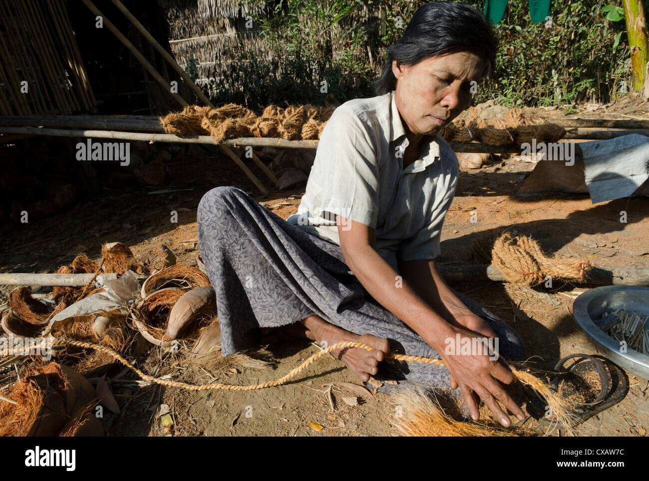 Woman making coconut rope, Ye Saing Kone village near Labutta, Irrawaddy Delta, Myanmar (Burma), Asia Stock Photo