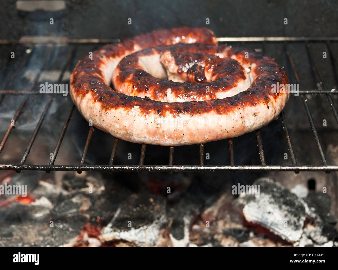 French Pork Sausage Cooking on a Charcoal Barbecue at Laval Midi-Pyrenees France Stock Photo