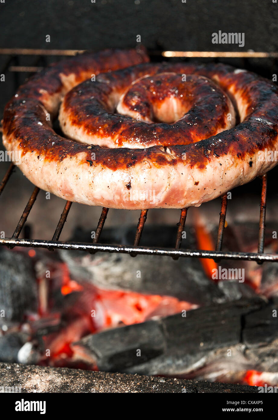 French Pork Sausage Cooking on a Charcoal Barbecue at Laval Midi-Pyrenees France Stock Photo