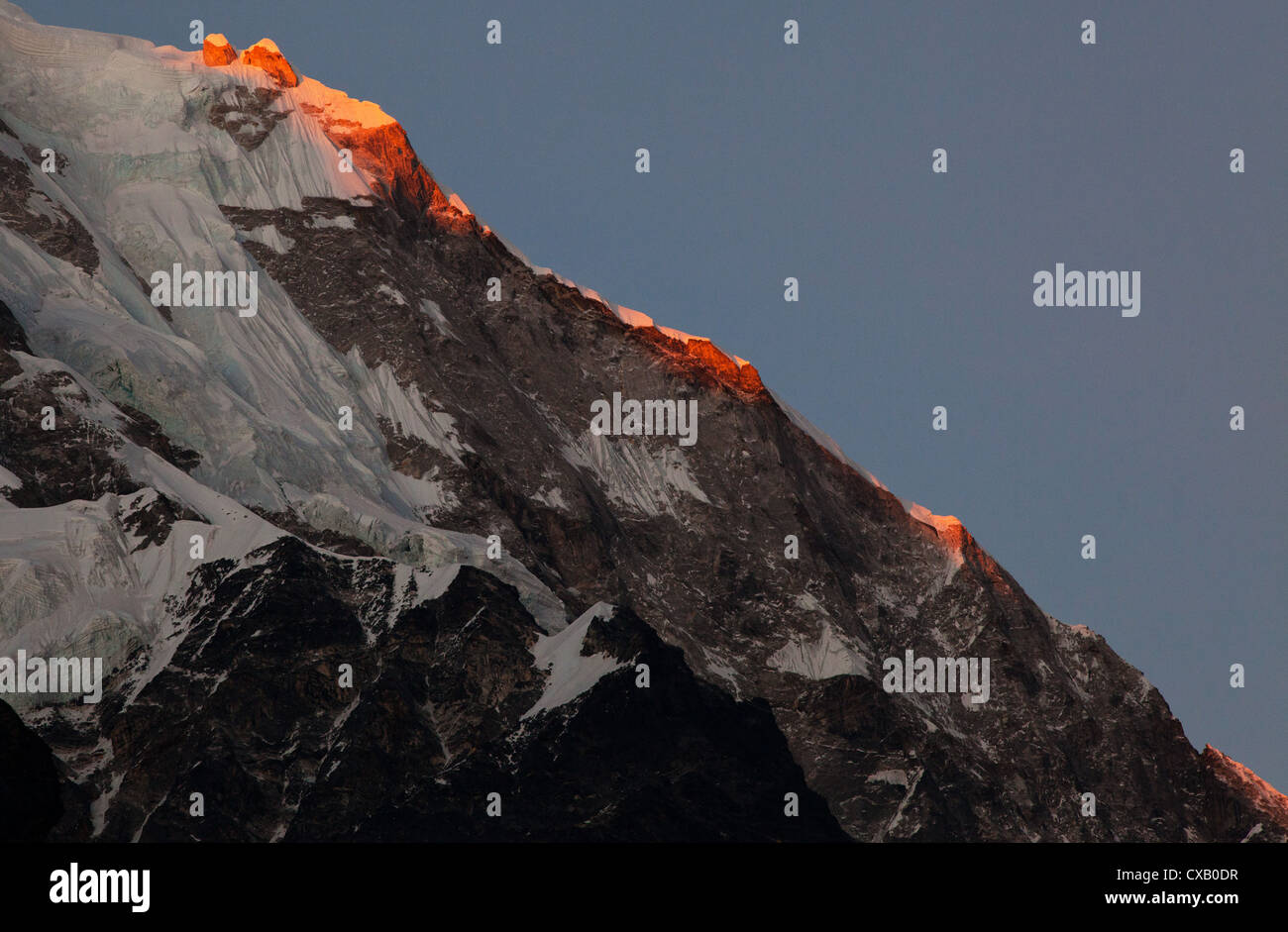 Sunlight hitting a snowcapped mountain along the Langtang Valley, Nepal Stock Photo