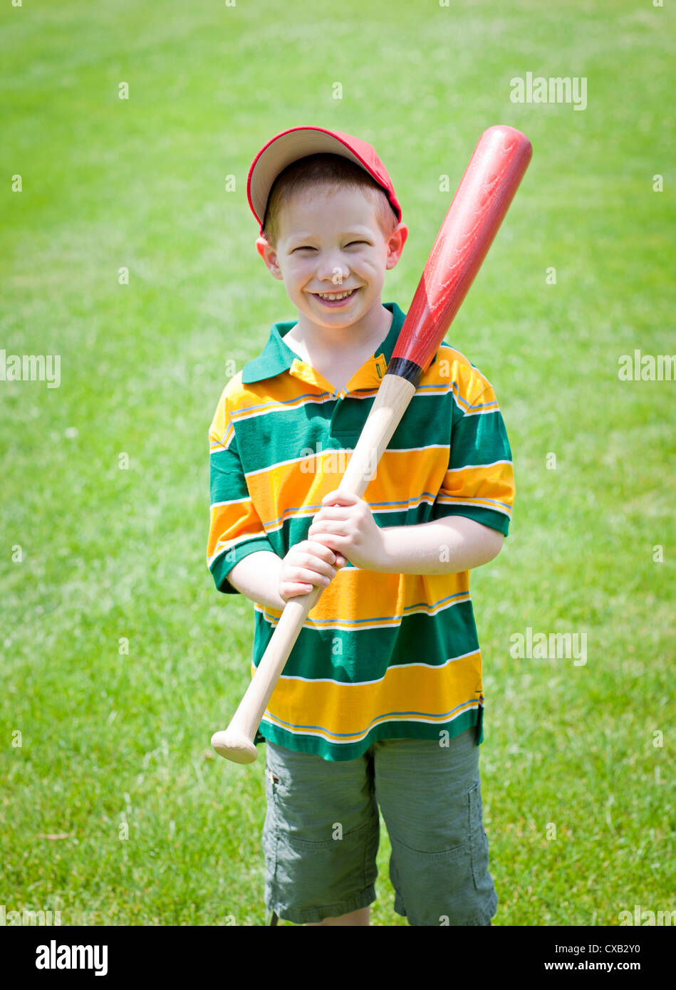 Cute boy with big smile outdoors on with baseball bat portrait Stock Photo