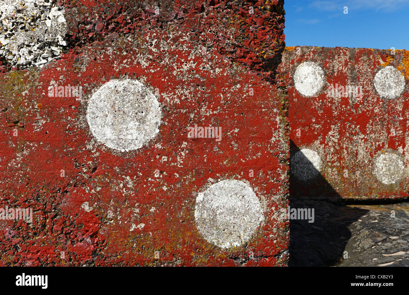 Giant concrete cubes found on Bamburgh beach in Northumberland painted as red dice. Stock Photo
