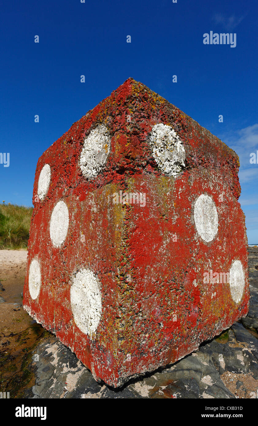 Giant concrete cubes found on Bamburgh beach in Northumberland painted as red dice. Stock Photo