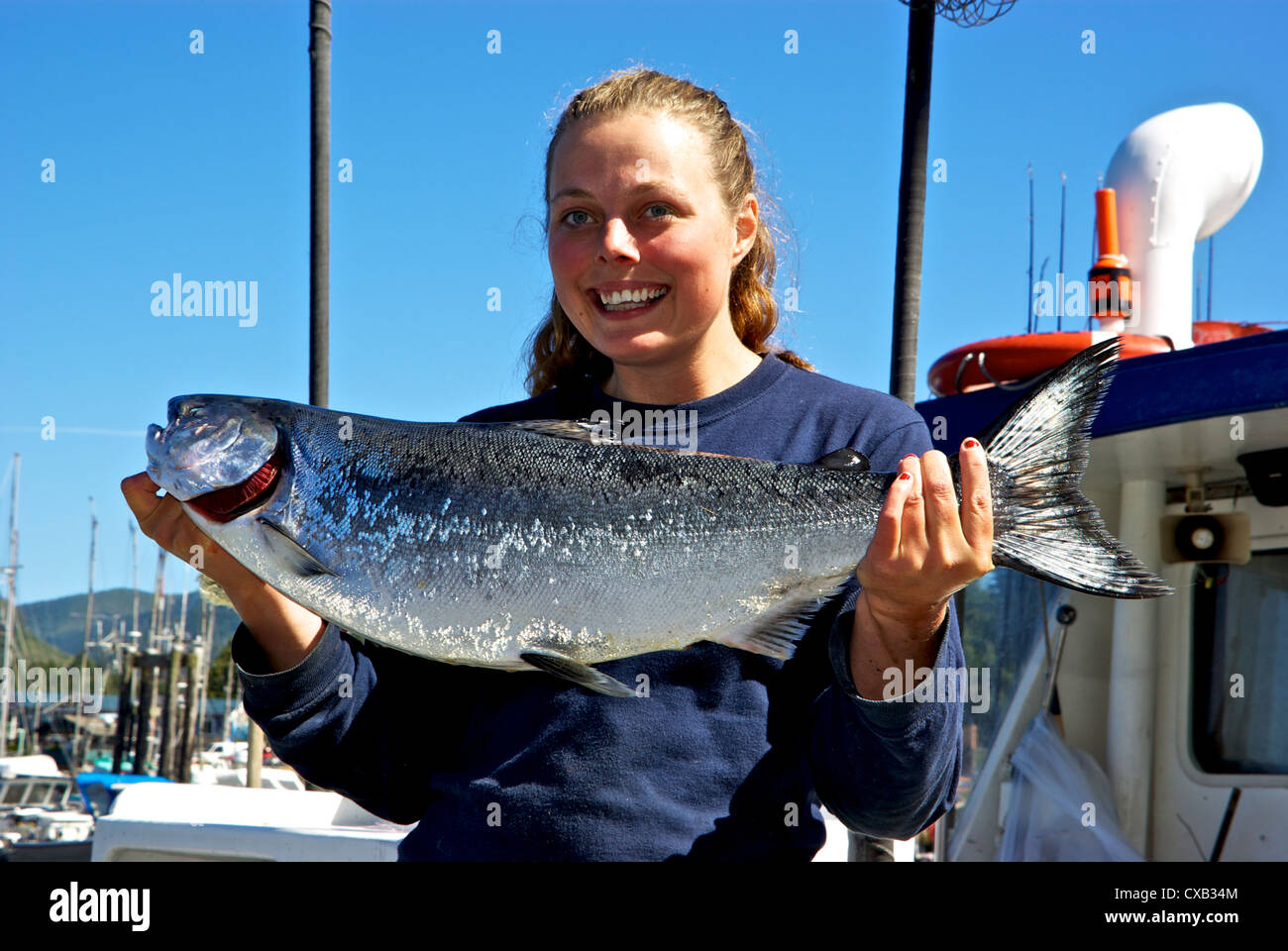 Female deckhand holding wild chinook salmon caught drift jigging