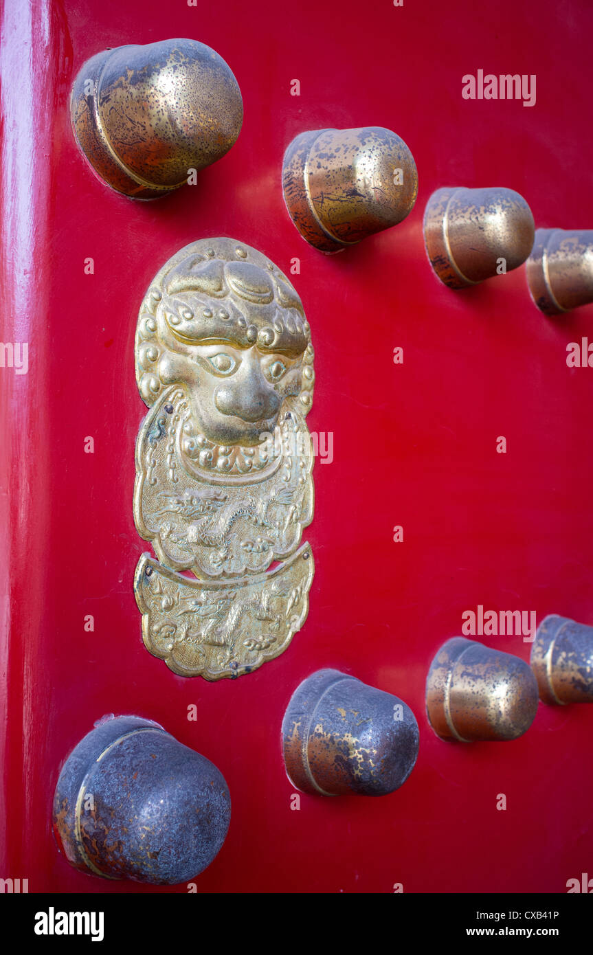 Traditional red ornate door at entrance to temple in Beijing China Stock Photo