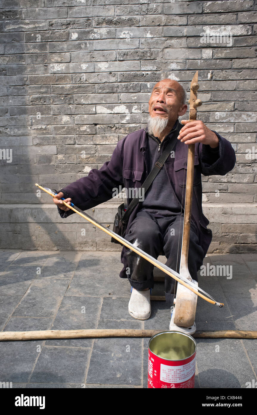 Blind man busking on street in old district of Beijing popular with tourists at Houhai China Stock Photo