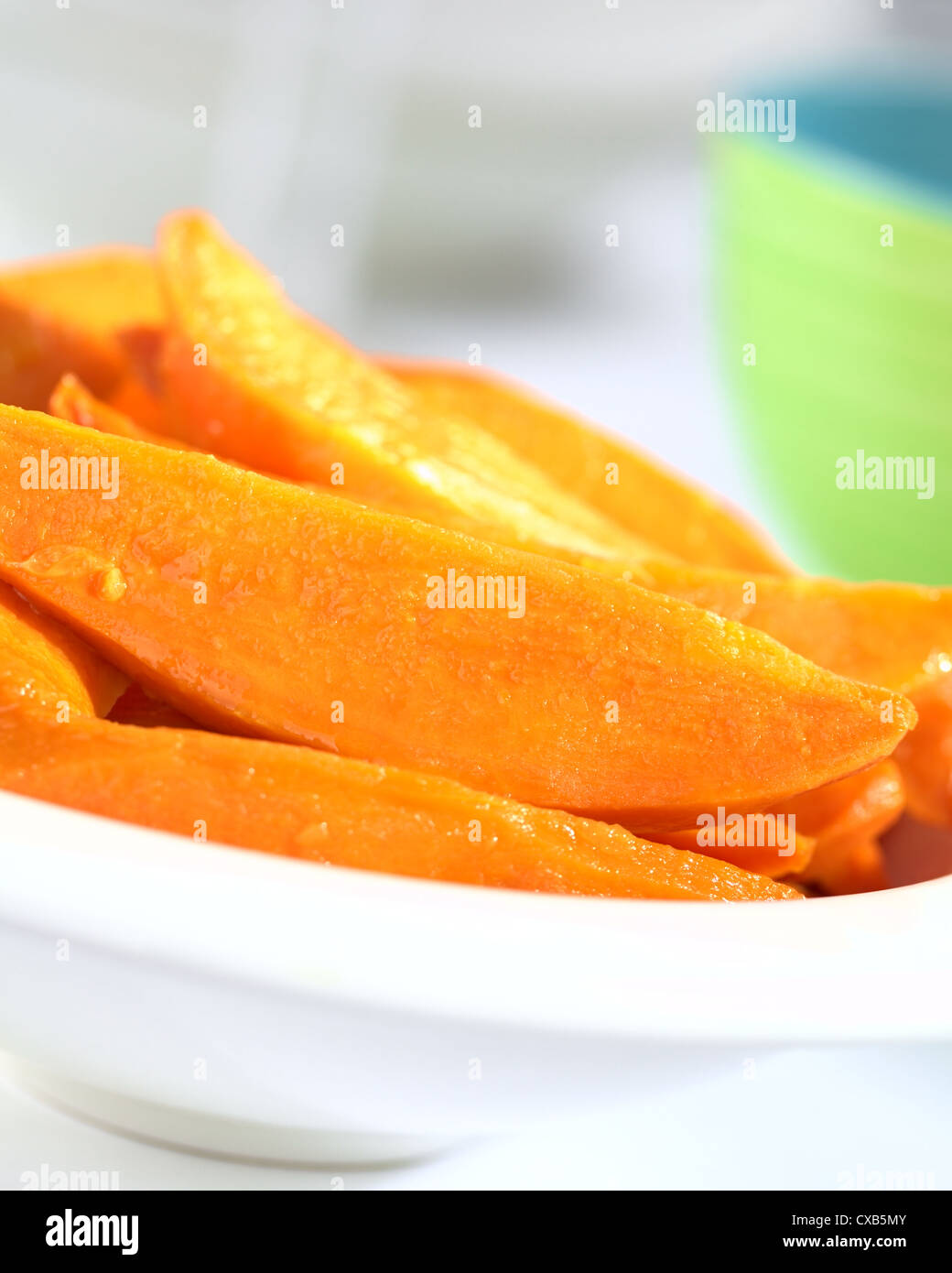 Fresh homemade caramelized sweet potato wedges in white bowl (Selective Focus, Focus one third into the sweet potatoes) Stock Photo
