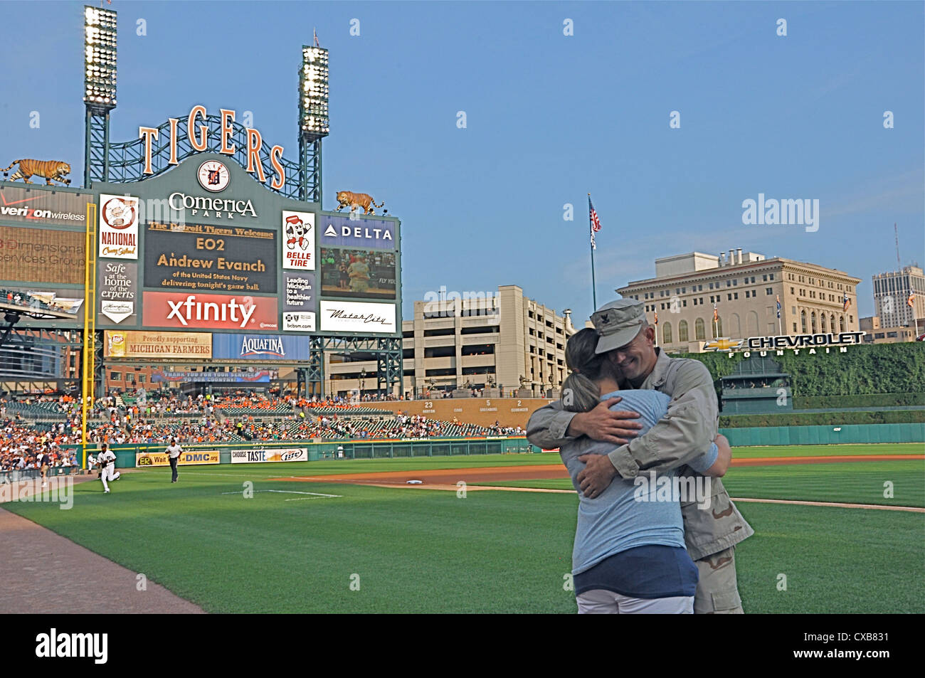 Petty Officer 2nd Class Andrew Evanch, assigned to Naval Mobile Construction Battalion 26, hugs his girlfriend after delivering the game ball before a baseball game between the Detroit Tigers and the Oakland Athletics. Evanch received a standing ovation for his role in support of Operation New Dawn. The event was part of Navy Night at Comerica Park during Detroit Navy Week, one of 21 Navy Weeks held across the country. Navy Weeks are designed to showcase the investment Americans have made in their Navy and increase awareness in cities that do not have a significant Navy presence. Stock Photo