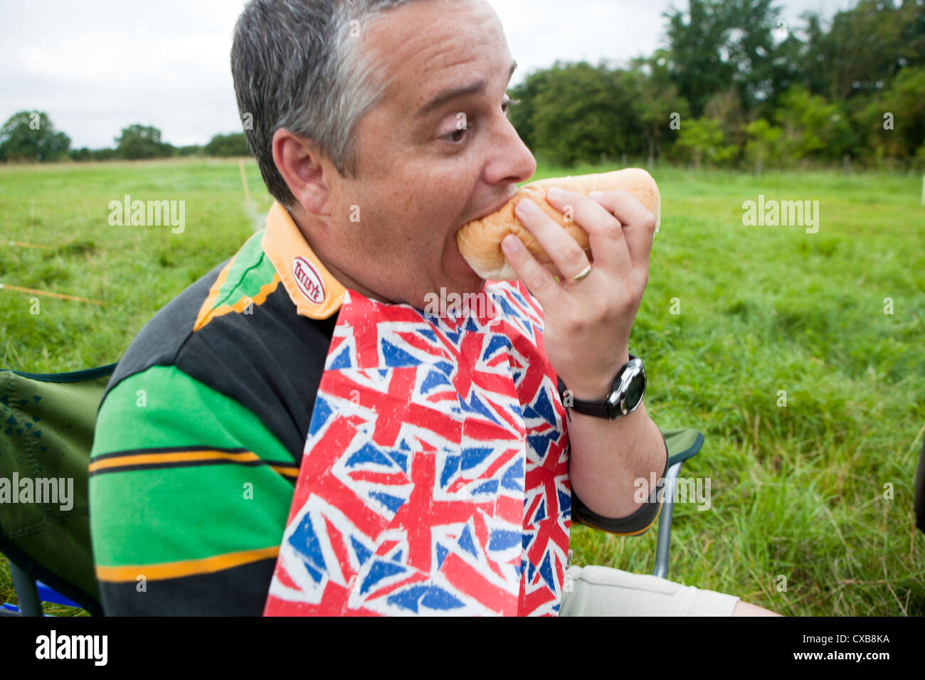 Hungry man taking big bite of bread Stock Photo