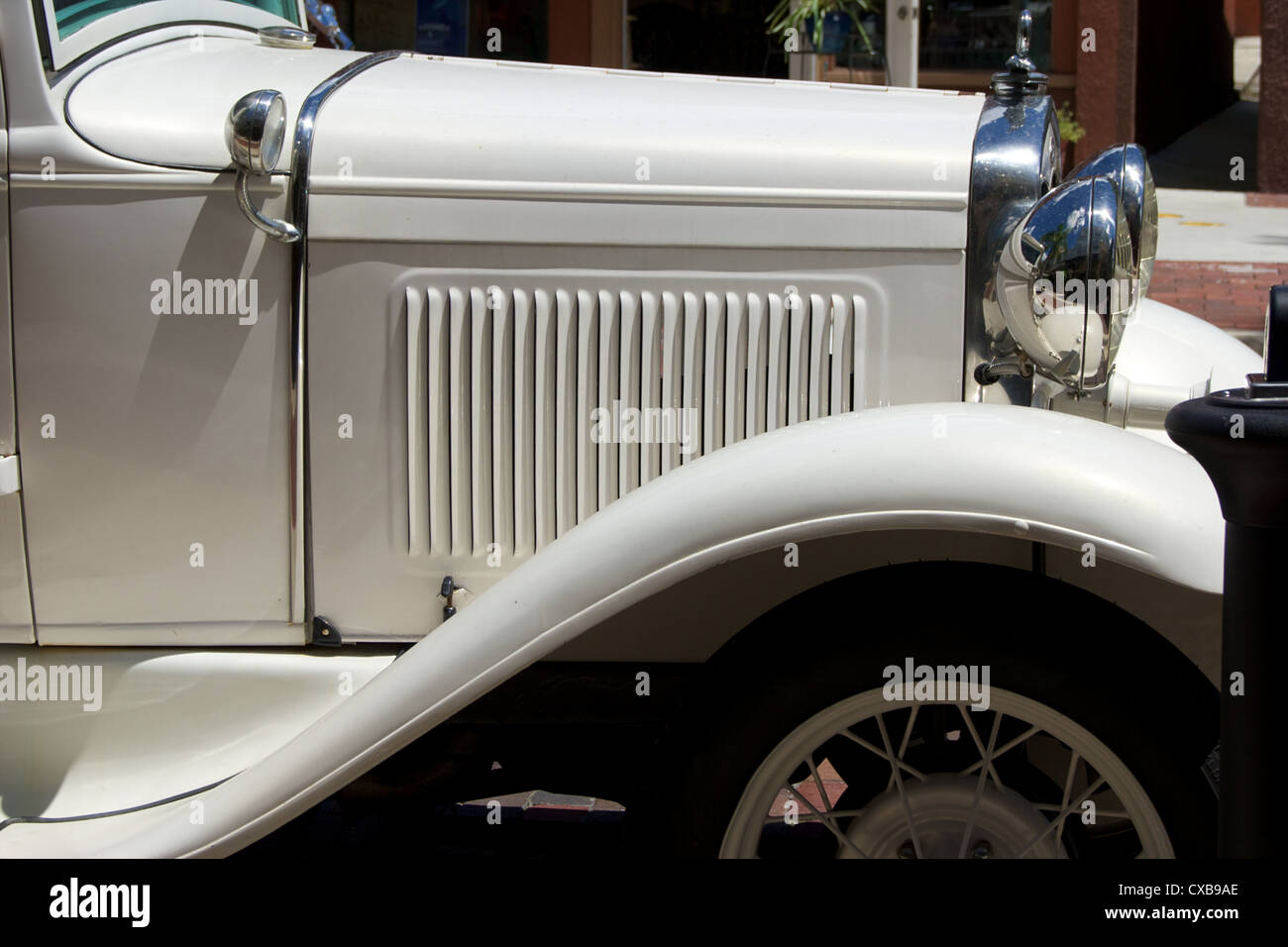 side view of old antique automobile, showing hood vents, fender and