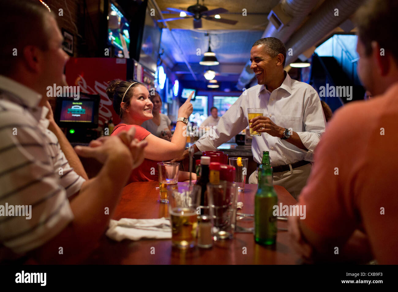 US President Barack Obama has a beer with patrons at the Pump Haus Pub and Grill August 14, 2012 in Waterloo, Iowa. Stock Photo