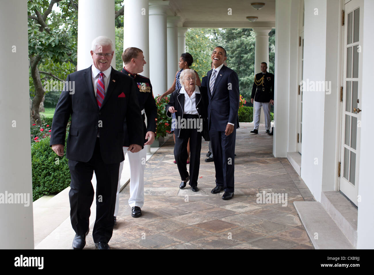 US President Barack Obama shares a laugh with Jean Meyer, the grandmother of Medal of Honor recipient Dakota Meyer, second from left September 15, 2011 as they and members of the Meyer family walk along the Colonnade of the White House. Stock Photo