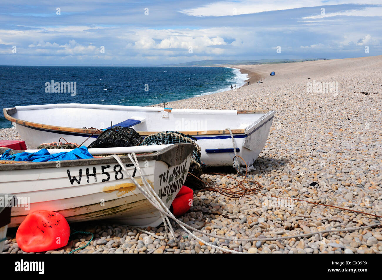 Chesil Beach with fishing boats pulled out on the shingle  on the Isle of Portland, near Weymouth, Dorset, England Stock Photo