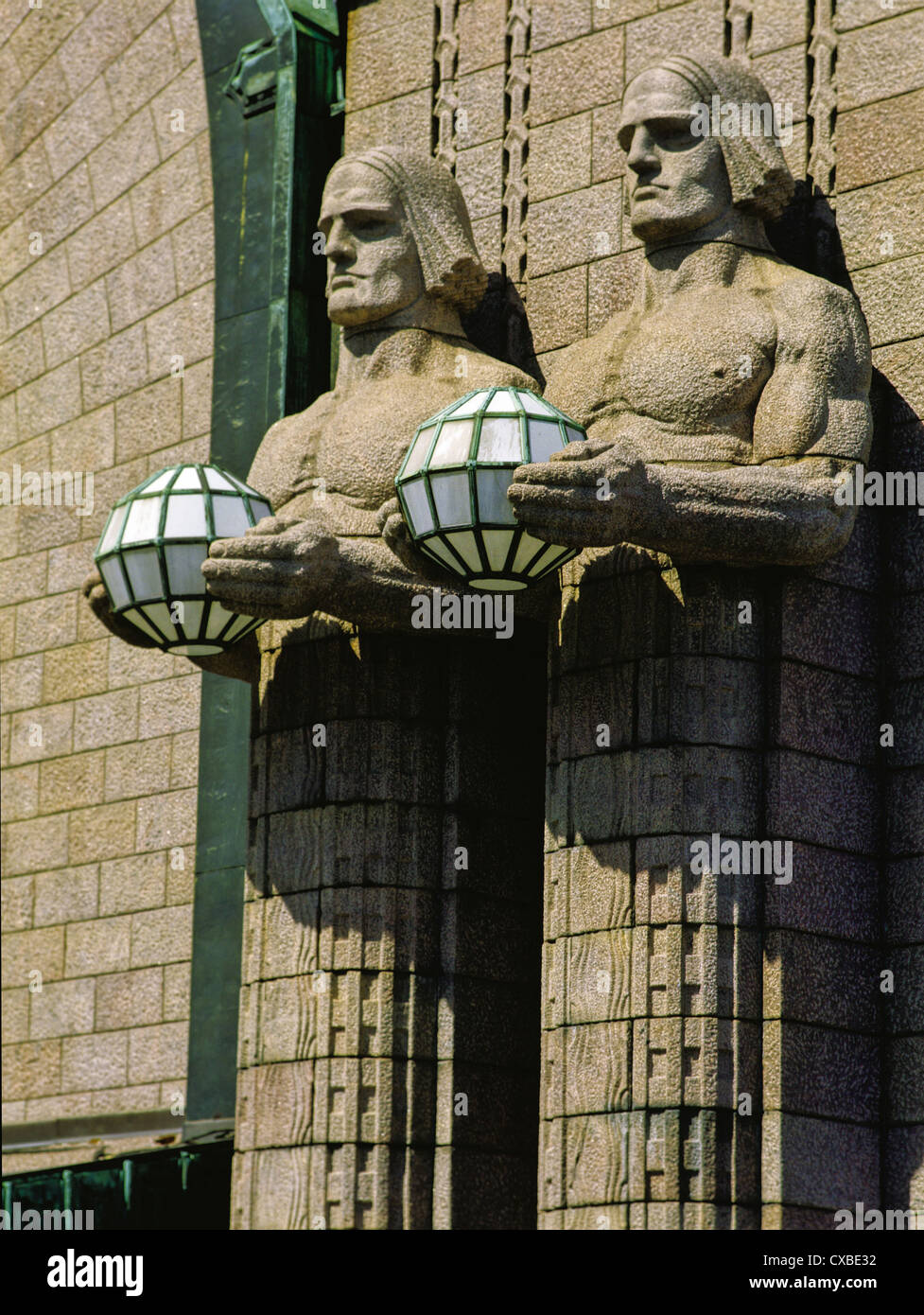 Granite statues holding lamps designed by Emil Wikstrom outside the Central Railway Station in Helsinki, Finland Stock Photo