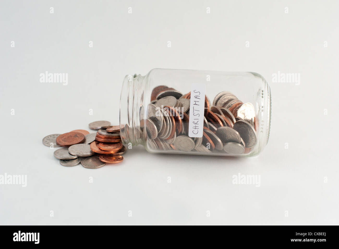 A glass jar of money with 'Christmas' label. Stock Photo