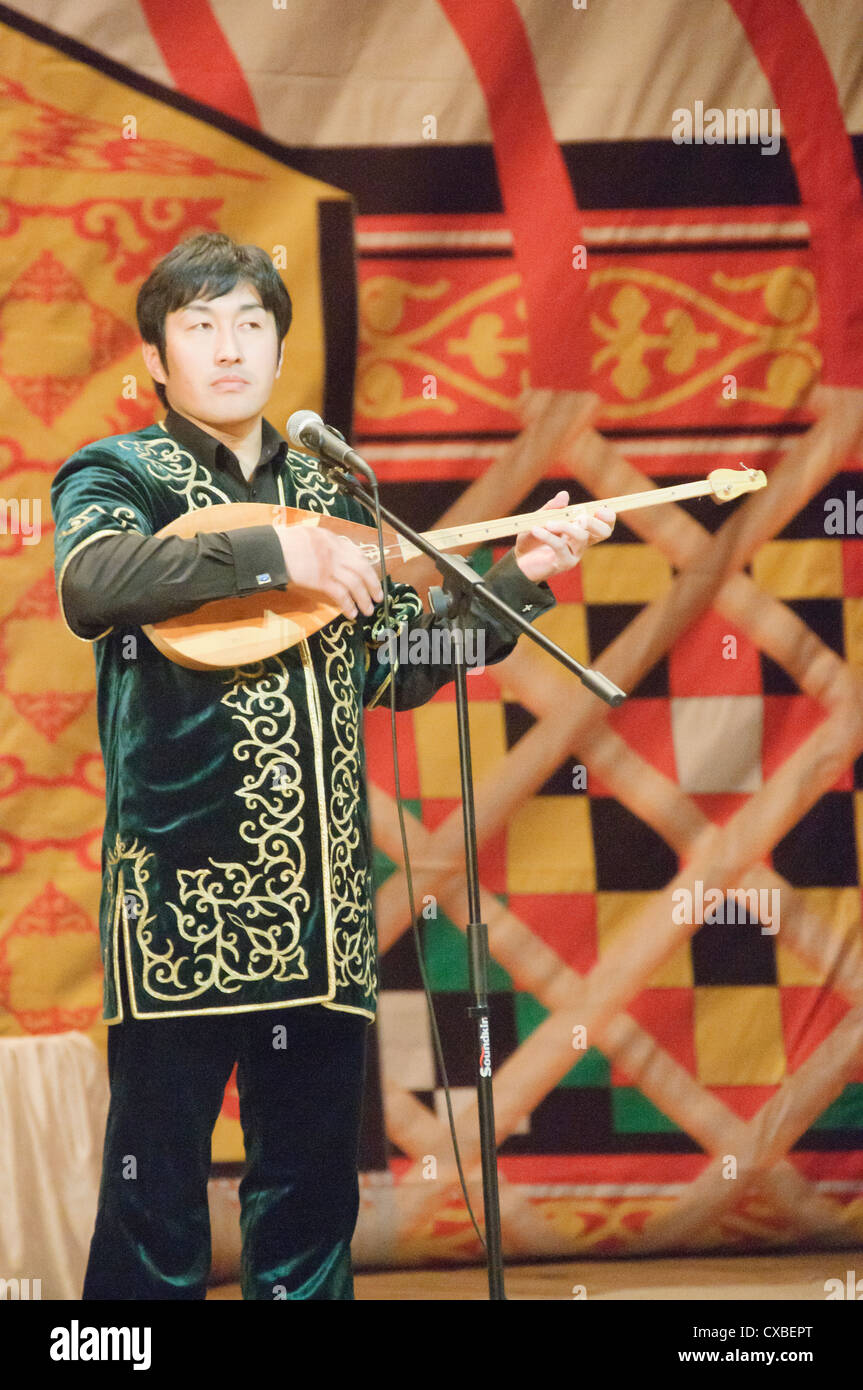 Kazakh musician playing a traditional dombra string instrument in Bayan ...